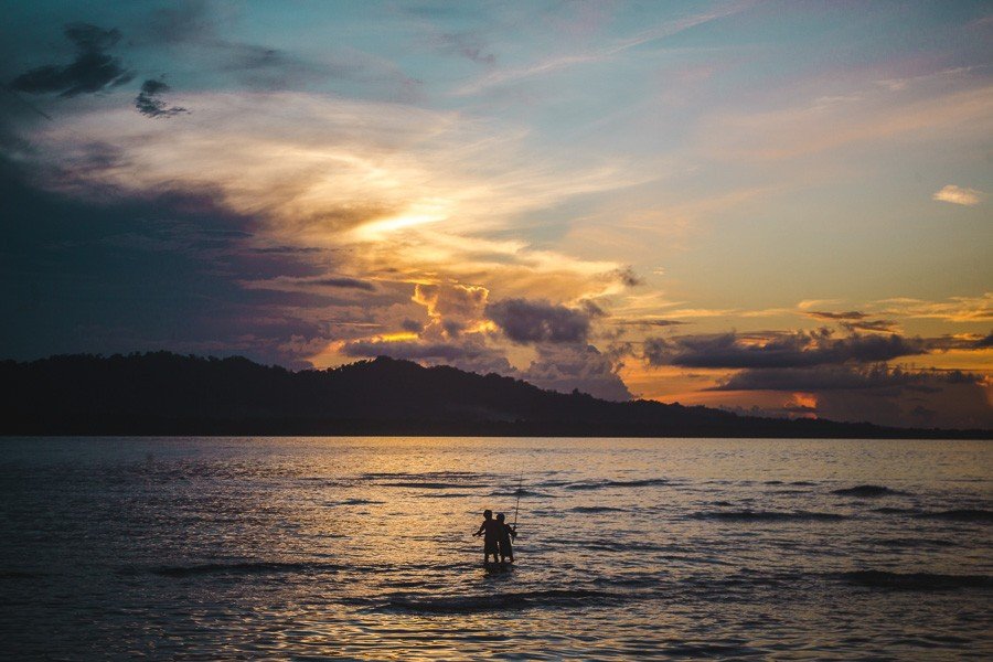 2 boys fishing at sunset in puerto viejo, costa rica
