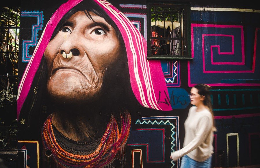 girl in a sweater next to graffiti in candelaria: what to wear in bogota colombia