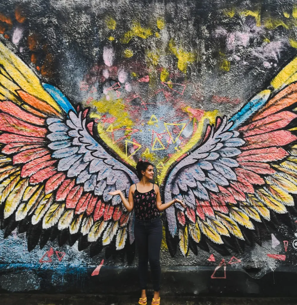 backpacker girl next to wing mural: why it's great for having travel on your résumé